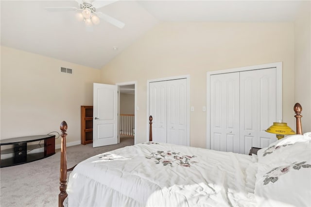 bedroom featuring light carpet, multiple closets, high vaulted ceiling, and ceiling fan