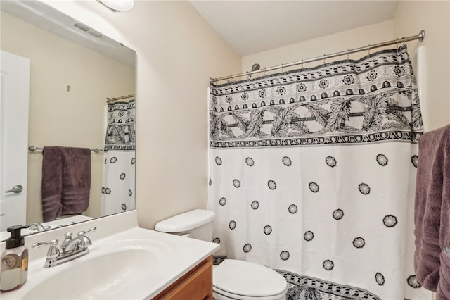 bathroom with vanity, curtained shower, and toilet