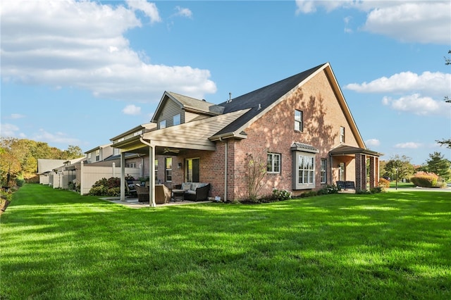 back of property with outdoor lounge area, a yard, and a patio area