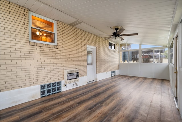 unfurnished sunroom with heating unit, vaulted ceiling, and ceiling fan