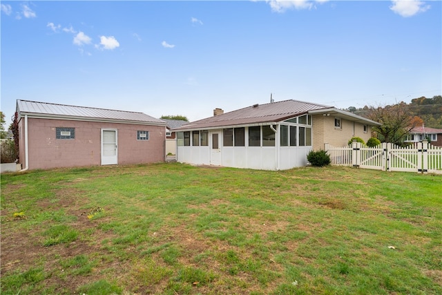 back of property with a lawn and a sunroom