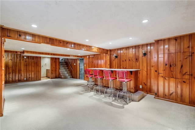 bar featuring carpet floors and wooden walls