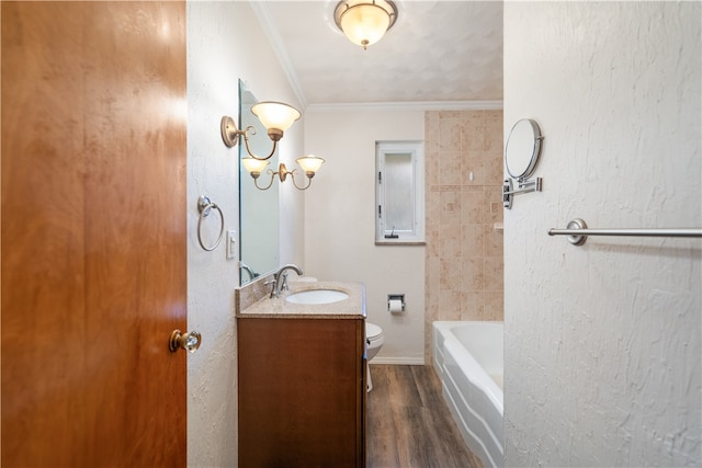 bathroom featuring wood-type flooring, a washtub, toilet, vanity, and crown molding