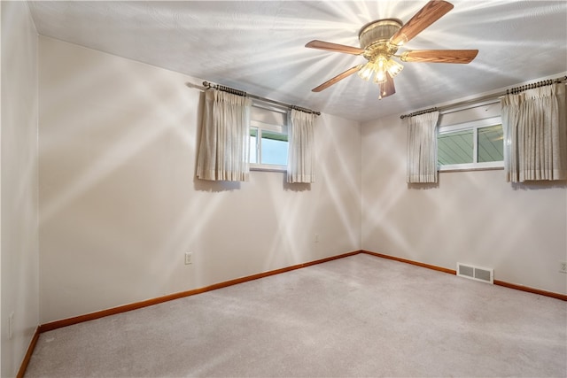 unfurnished room featuring a textured ceiling, carpet flooring, plenty of natural light, and ceiling fan