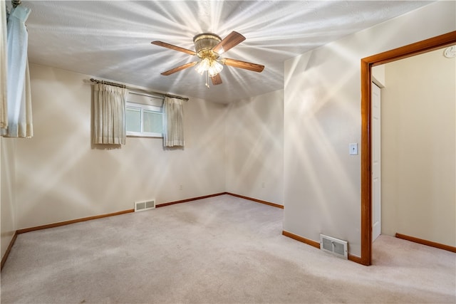 carpeted empty room with ceiling fan and a textured ceiling