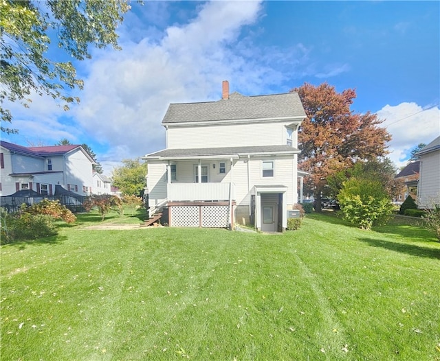 rear view of property featuring a yard