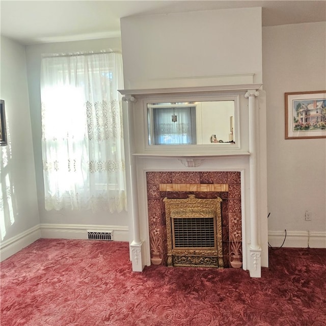 interior details with a tiled fireplace and carpet