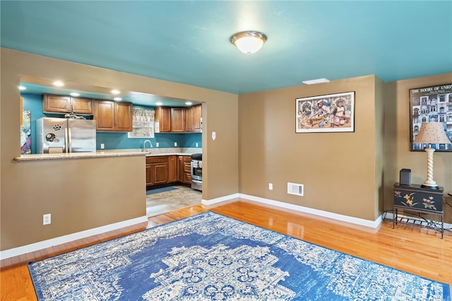 kitchen featuring stainless steel appliances, sink, and light wood-type flooring