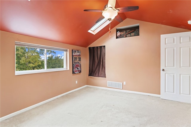 interior space with carpet flooring, vaulted ceiling with skylight, and ceiling fan