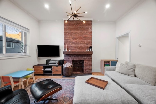 living room featuring an inviting chandelier, crown molding, light wood-type flooring, and a brick fireplace