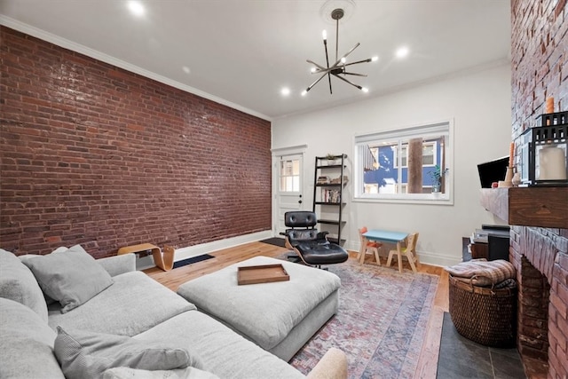 living room featuring hardwood / wood-style flooring, brick wall, ornamental molding, and a chandelier