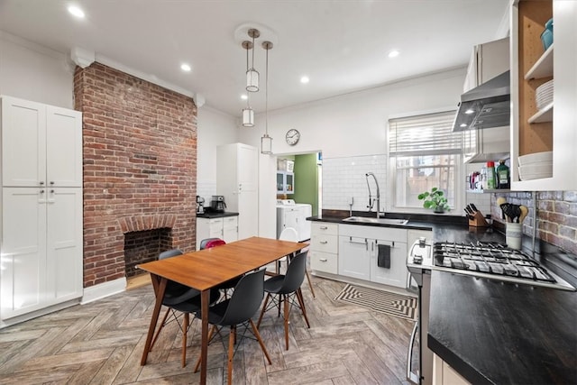 kitchen featuring hanging light fixtures, white cabinetry, light parquet flooring, crown molding, and sink