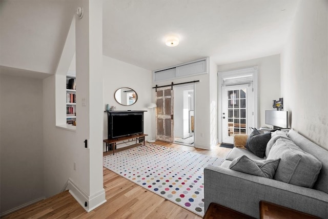 living room with light hardwood / wood-style flooring and a barn door