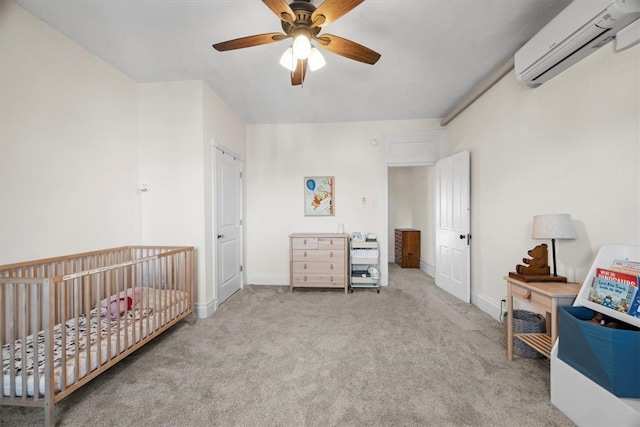 bedroom featuring a wall unit AC, a nursery area, light colored carpet, and ceiling fan