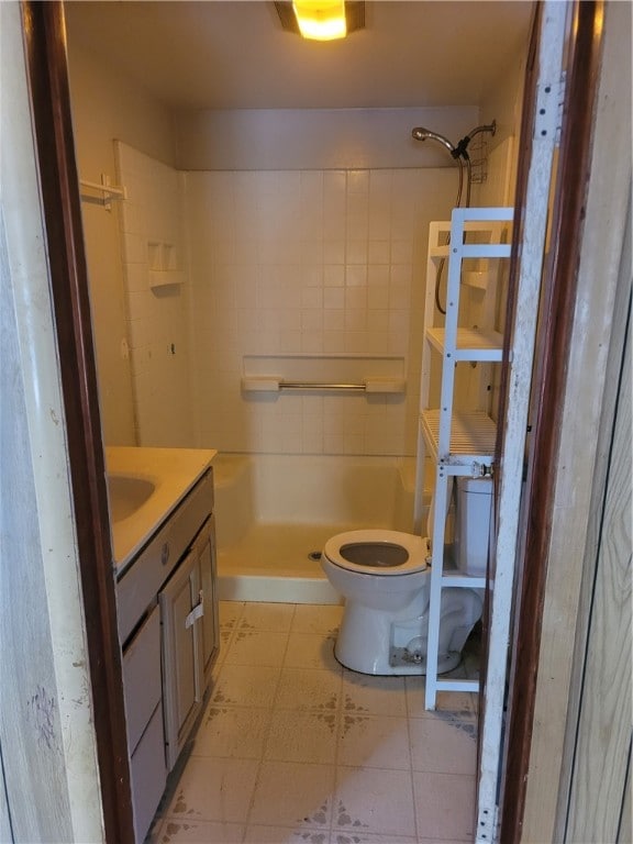 bathroom featuring vanity, toilet, tile patterned floors, and a shower