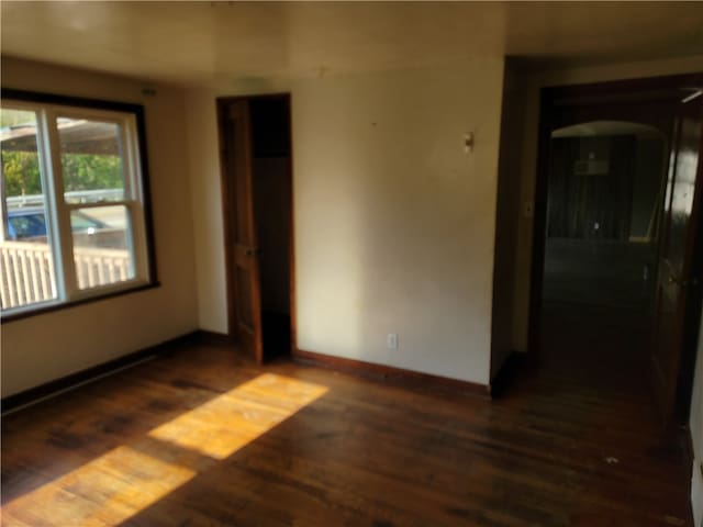 unfurnished room featuring dark hardwood / wood-style flooring