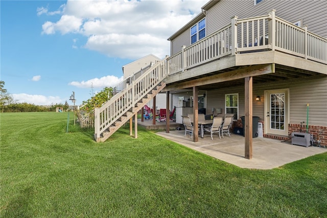 back of property featuring a wooden deck, a yard, and a patio area