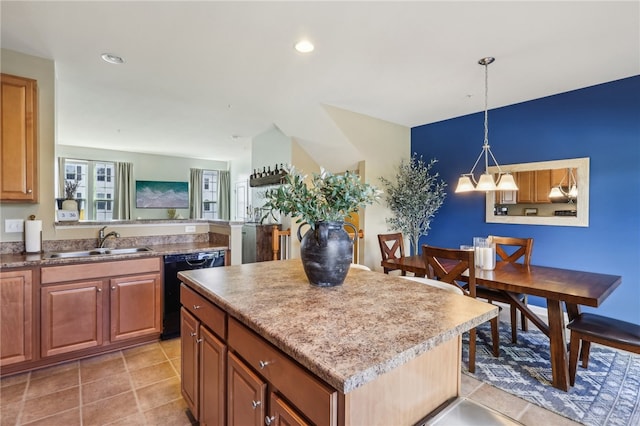 kitchen featuring black dishwasher, a center island, light tile patterned flooring, sink, and decorative light fixtures