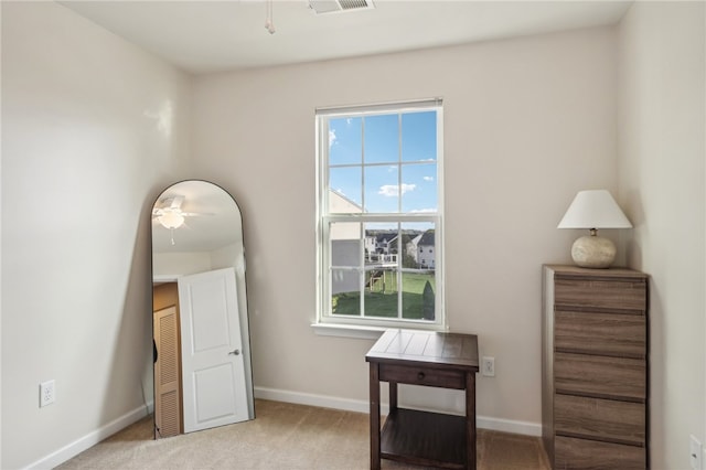 interior space featuring light carpet and ceiling fan