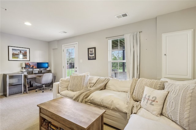 living room featuring plenty of natural light and light colored carpet