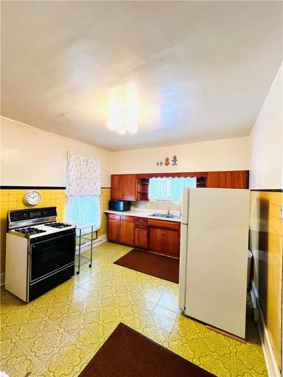 kitchen with white refrigerator, range, and sink