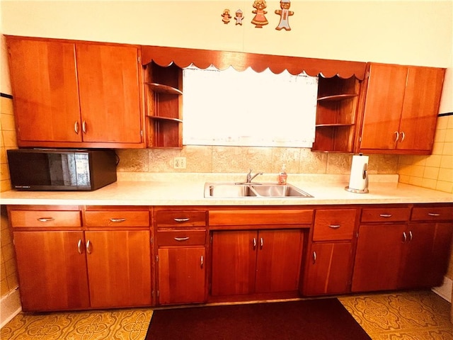 kitchen featuring decorative backsplash, light tile patterned floors, and sink