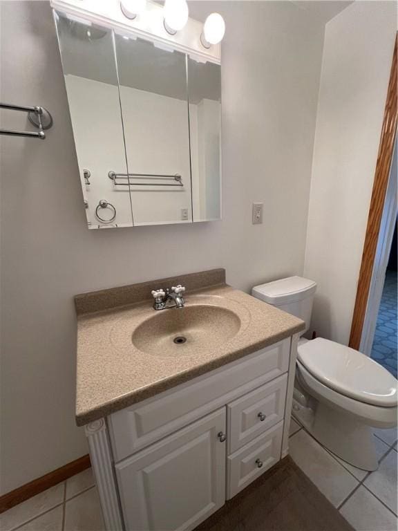 bathroom featuring tile patterned flooring, vanity, and toilet