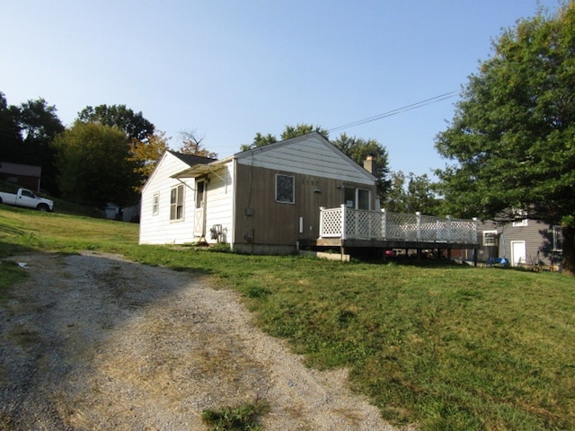 view of front of property with a front yard and a wooden deck