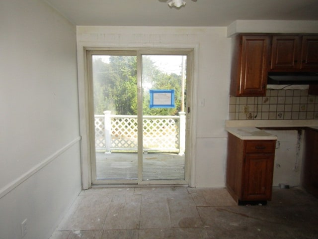 kitchen featuring decorative backsplash and exhaust hood