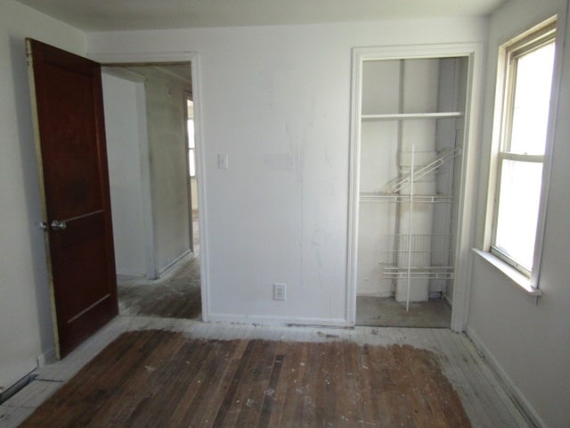 unfurnished bedroom with a closet and dark hardwood / wood-style flooring