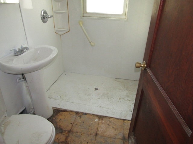 bathroom featuring toilet and walk in shower