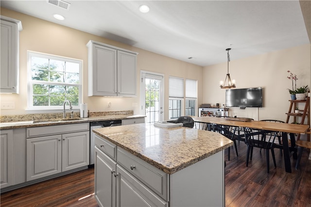 kitchen featuring sink, a center island, dark hardwood / wood-style floors, and a healthy amount of sunlight