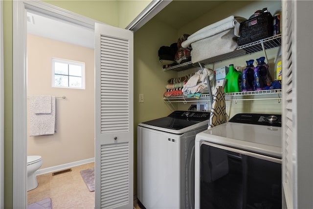 laundry room featuring washing machine and dryer and light tile patterned floors