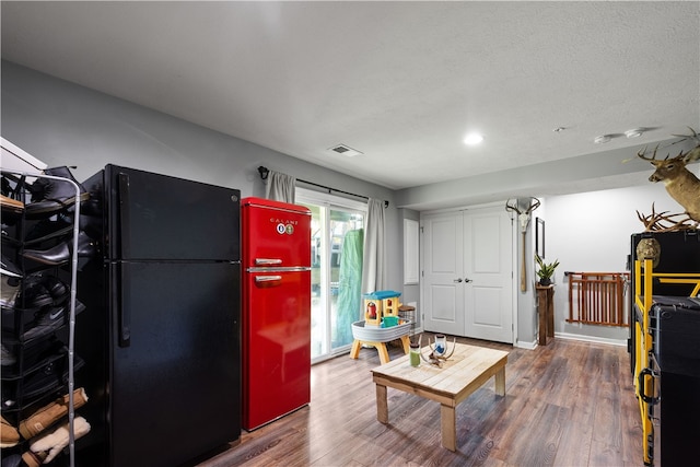 interior space featuring a textured ceiling and wood-type flooring