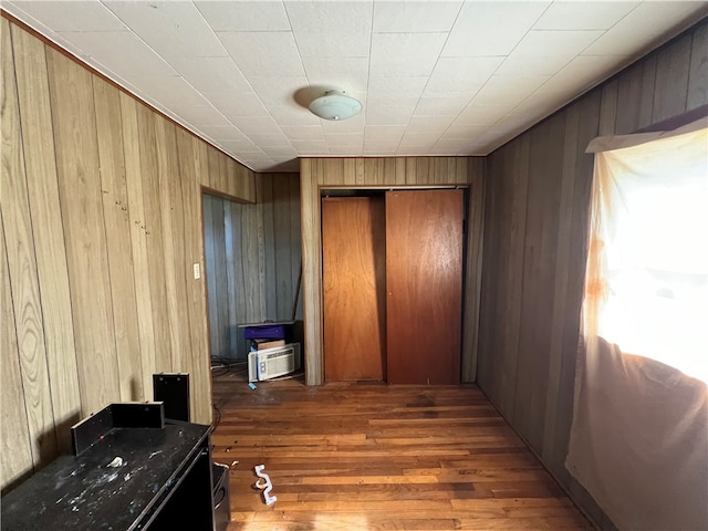 hallway with light hardwood / wood-style floors and wooden walls