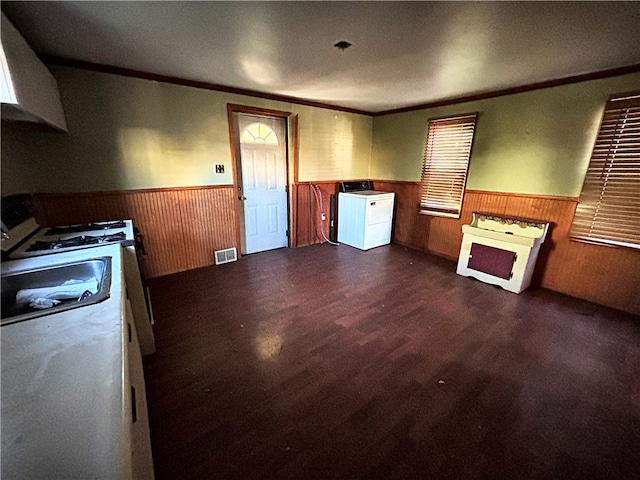 kitchen with wood walls, crown molding, washer / clothes dryer, and dark hardwood / wood-style flooring