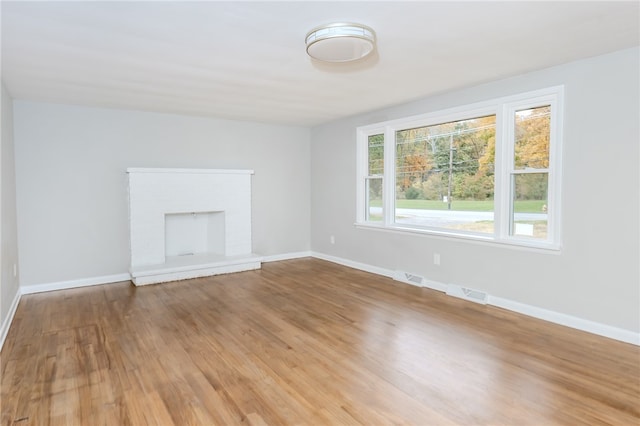 unfurnished living room with a fireplace and wood-type flooring