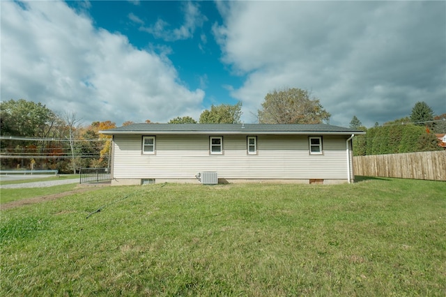 rear view of property featuring a yard and central air condition unit