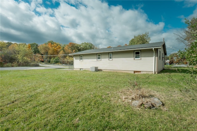 back of house with central AC, volleyball court, and a lawn