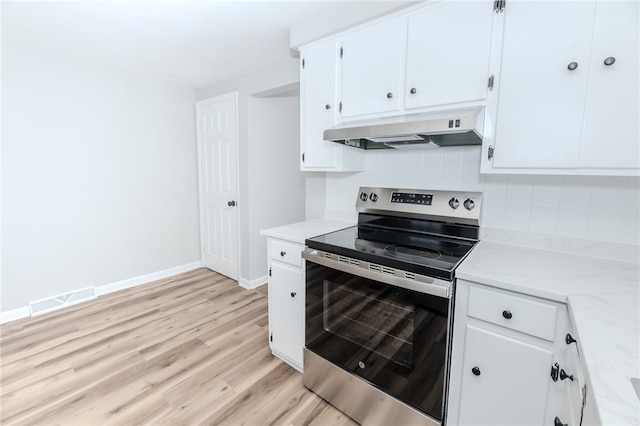 kitchen featuring backsplash, white cabinets, light stone counters, stainless steel electric range oven, and light hardwood / wood-style flooring