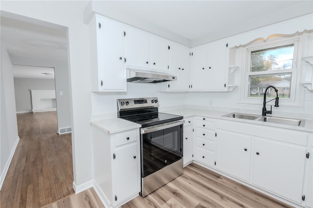 kitchen with light hardwood / wood-style floors, white cabinetry, sink, and stainless steel electric range oven