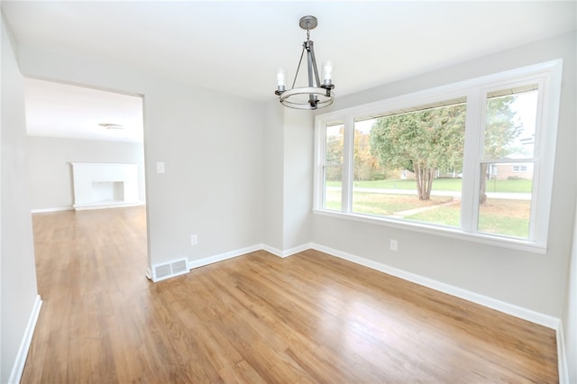 interior space featuring light hardwood / wood-style flooring, a healthy amount of sunlight, and a chandelier