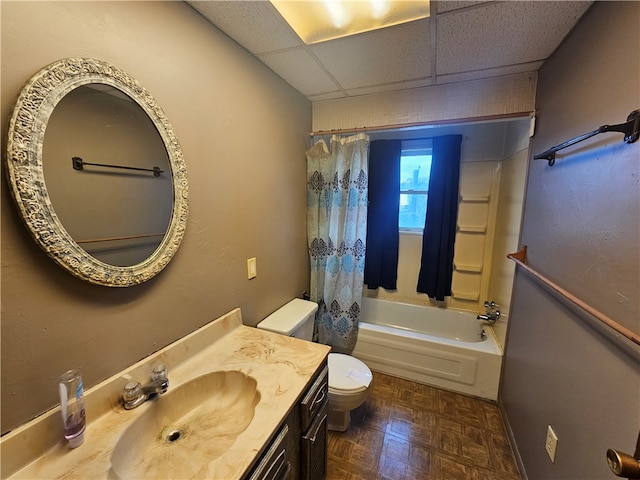 full bathroom with a paneled ceiling, toilet, parquet floors, vanity, and shower / tub combo with curtain