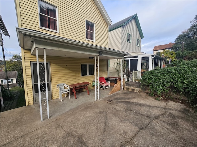 back of house with a patio area and a sunroom