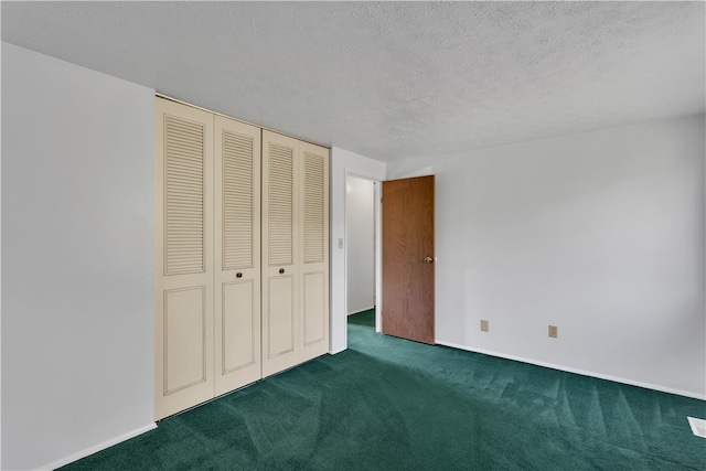 unfurnished bedroom with dark carpet, a textured ceiling, and a closet