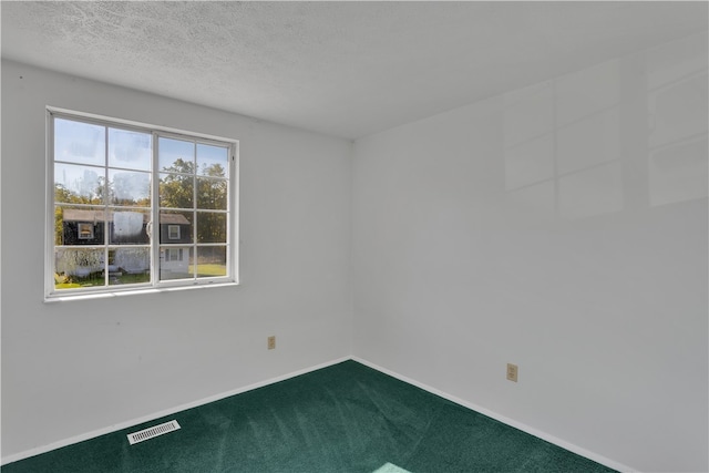 carpeted spare room featuring a textured ceiling