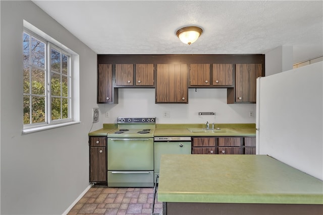 kitchen featuring range with electric cooktop, sink, a textured ceiling, stainless steel dishwasher, and white refrigerator