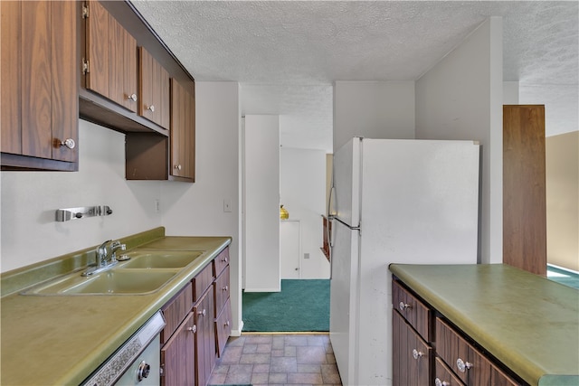 kitchen with white appliances, light carpet, a textured ceiling, and sink