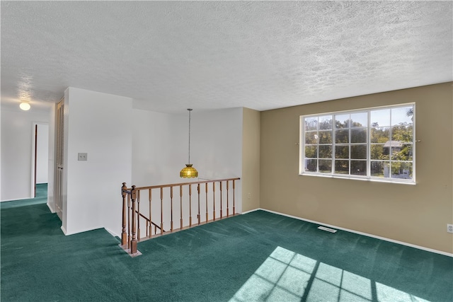 carpeted empty room featuring a textured ceiling