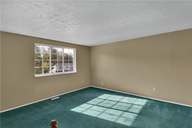 carpeted empty room with a textured ceiling